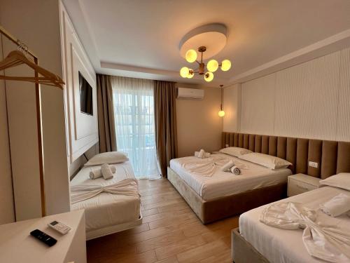 um quarto de hotel com duas camas e um lustre em The Wish House em Golem