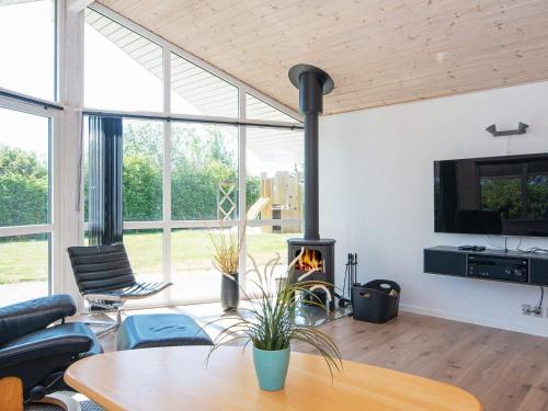 a living room with a fireplace and a table at 6 person holiday home in Hemmet in Falen