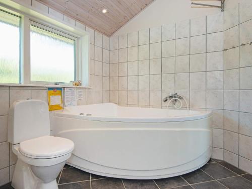 a bathroom with a white tub and a toilet at 6 person holiday home in Hemmet in Falen