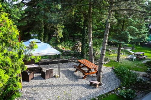 ein Picknicktisch und ein Zelt in einem Park in der Unterkunft Pokoje gościnne „SEN” in Iława