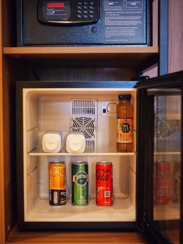 an open refrigerator with cans of drinks in it at Golden Tulip Dieppe Hôtel & Spa in Saint-Aubin-sur-Scie