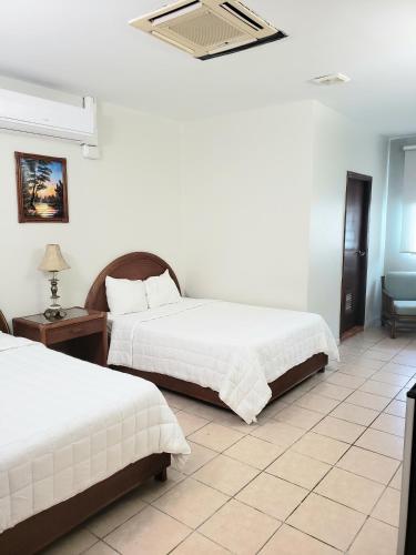 a bedroom with two beds and a table and a chair at Parador El Buen Cafe in Hatillo