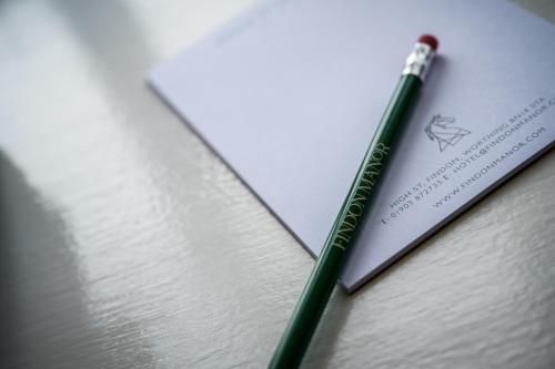 a green pen sitting on top of a piece of paper at Findon Manor Hotel in Worthing