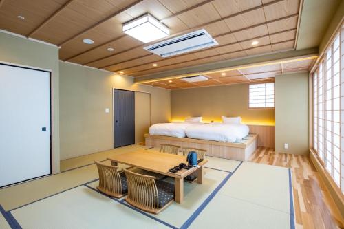 a room with a bed and a table and chairs at Ryokan Ginkaku Kyoto in Kyoto