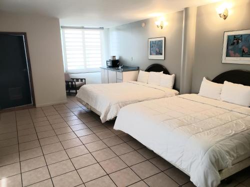 a bedroom with two beds and a tiled floor at Parador El Buen Cafe in Hatillo