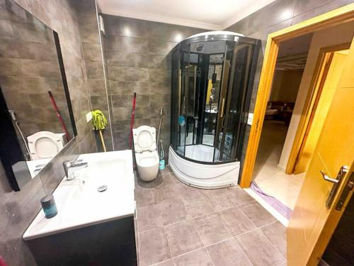 ein Badezimmer mit einer Dusche, 2 WCs und einem Waschbecken in der Unterkunft Luxurious apartment with swimming pool and playground in Oued Laou