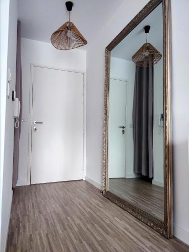 an empty room with a mirror and a door at T2 en centre ville avec place de parking privative in Le Mans