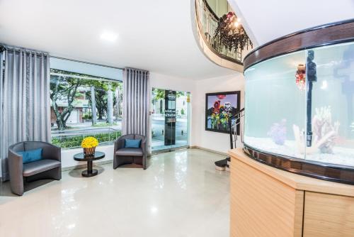 an empty living room with an aquarium at Hotel Asturias Medellin in Medellín