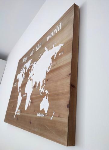 a wooden map of the world hanging on a wall at T2 en centre ville avec place de parking privative in Le Mans