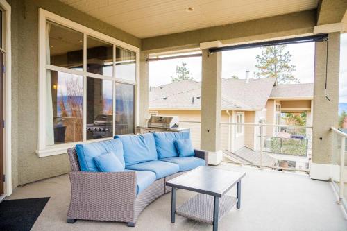 a blue couch sitting on a porch with a table at Kelowna Spacious 2 Bedrooms House in Kelowna