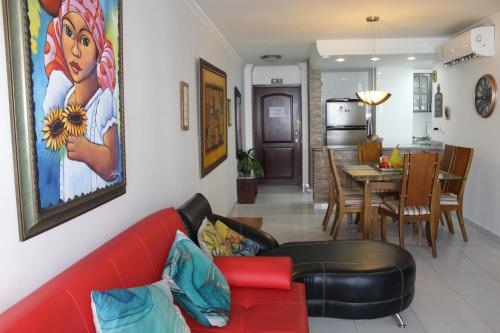 a living room with a red couch and a dining room at Cartagena - Torremarina in Cartagena de Indias