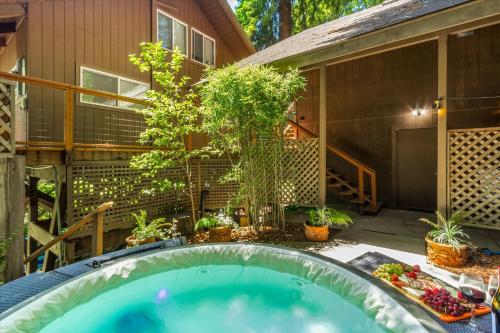 a backyard pool with a hot tub and plants at Lazy River Lodge - Hot Tub On the River Kayaks in Guerneville