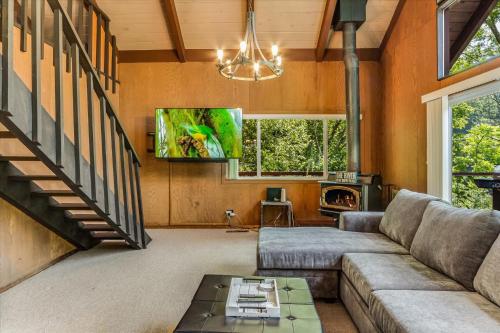 a living room with a couch and a fireplace at Lazy River Lodge - Hot Tub On the River Kayaks in Guerneville