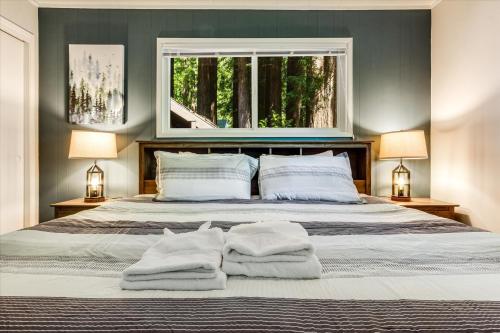 a bedroom with a large bed with towels on it at Lazy River Lodge - Hot Tub On the River Kayaks in Guerneville