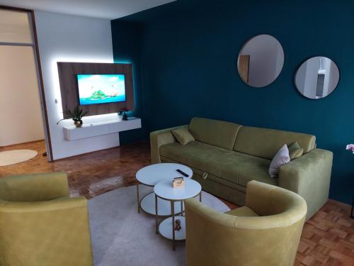 sala de estar con sofá, sillas y TV en Apartman Minja, en Višegrad