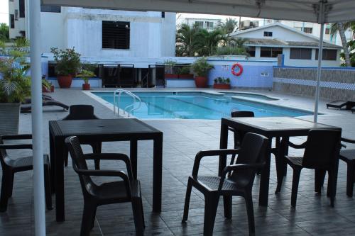 una mesa y sillas frente a una piscina en Cartagena - Torremarina, en Cartagena de Indias