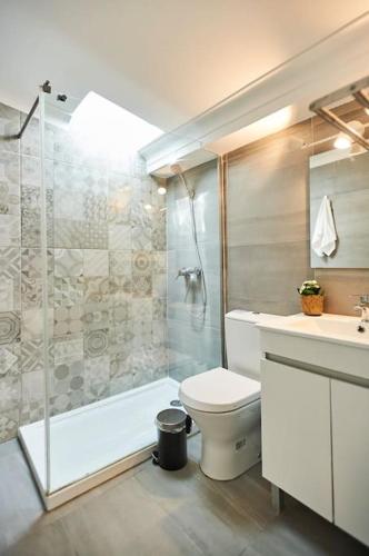 a bathroom with a shower and a toilet and a sink at Timeless Loft at the Village in Ericeira