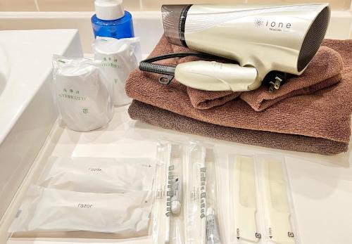 a bathroom counter with a hair dryer and other items at Fujisan Garden Hotel in Yamanakako