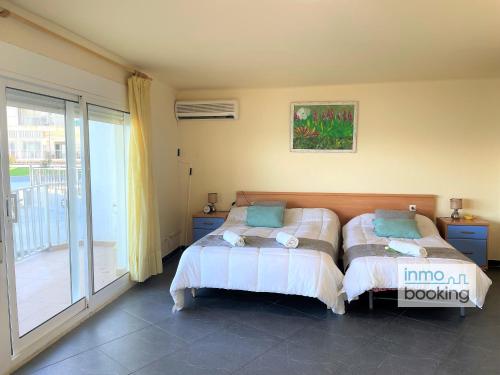 a bedroom with two beds and a balcony at Sun Beach Acantilados La Mar in Salou