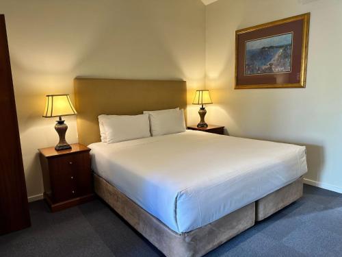 a bedroom with a large bed with two lamps at Brooklands Of Mornington in Mornington
