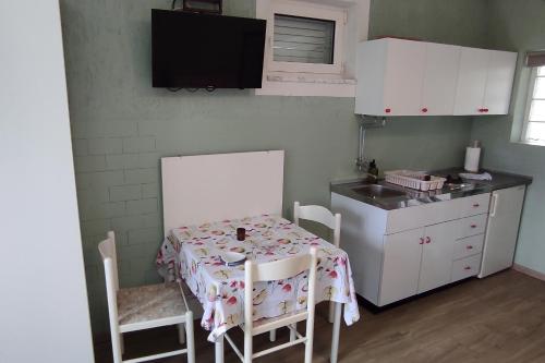 una cocina con mesa y 2 sillas y una cocina con fregadero en Studio Punat 5410a, en Punat