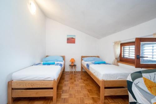 um quarto com duas camas e uma janela em Apartments with a parking space Preko, Ugljan - 8179 em Preko