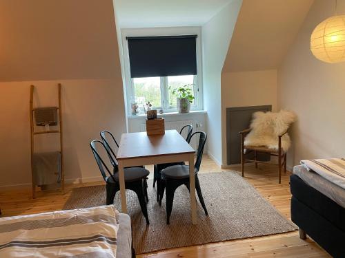 een eetkamer met een tafel en stoelen en een raam bij Room 17 - Hawkraft kulturhotel in Vestervig