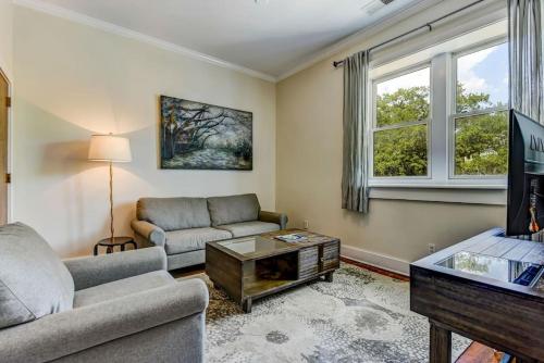 a living room with a couch and a tv at Loft steps from City Hall and River Street in Savannah