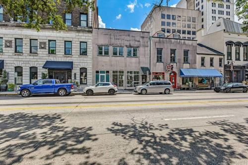 a street with cars parked in front of buildings at Loft steps from City Hall and River Street in Savannah