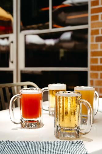 three glasses of beer sitting on a table at The Carpenter Hotel in Austin