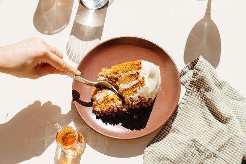 a person eating a piece of cake on a plate at The Carpenter Hotel in Austin