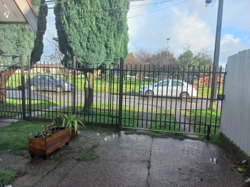 a black fence with cars parked in a parking lot at Mini Casa Rocura Valdivia in Valdivia