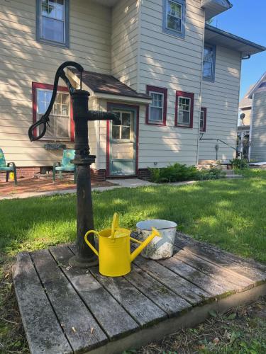 a water pump and buckets on a table in a yard at Historic Downtown Brownsburg Home w/Charm in Brownsburg
