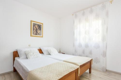 1 dormitorio blanco con 2 camas y ventana en Apartments with a parking space Kastel Stari, Kastela - 20999, en Kaštela
