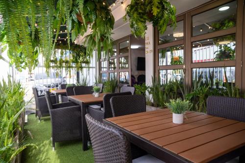 een restaurant met houten tafels, stoelen en planten bij BLISS BOUTIQUE HOTEL BOGOTA in Bogota
