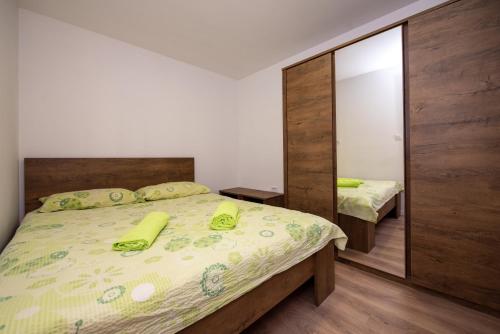 - une chambre dotée d'un lit avec des draps jaunes et un miroir dans l'établissement Apartments with a parking space Split - 21525, à Split