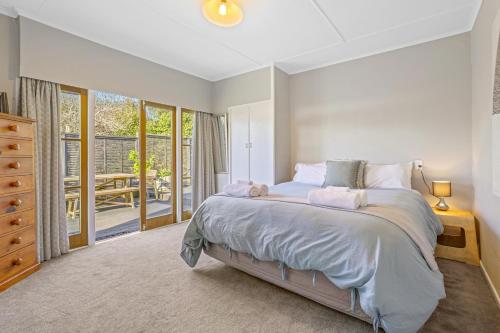 a bedroom with a large bed and a balcony at Redwoods Retreat in Rotorua