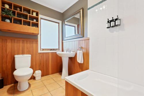 a bathroom with a toilet and a sink at Redwoods Retreat in Rotorua