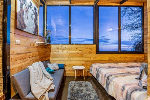 a room with two beds and a bench and windows at Tiny House Jaulares in Rivas