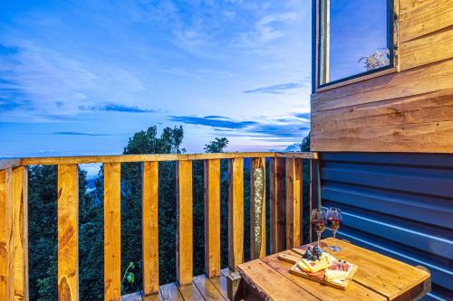 a wooden table with wine glasses on a balcony at Tiny House Jaulares in Rivas