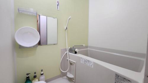 a bathroom with a sink and a toilet and a mirror at Nagahigawa in Miyazaki