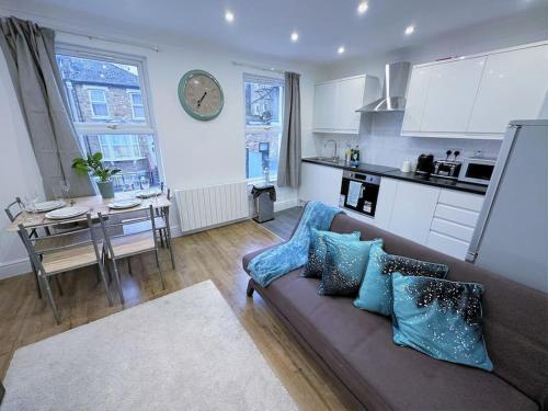 uma sala de estar com um sofá e uma cozinha em (ZONE 2) STYLISH 2 BED FLAT IN THE HEART OF LEWISHAM em Londres