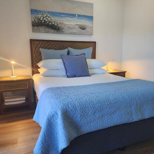 a bedroom with a bed with a blue comforter at Elysium Apartments in Palm Cove
