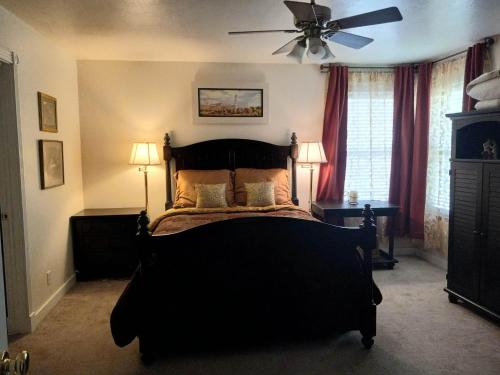 a bedroom with a black bed with a ceiling fan at Red Creek Inn and Farm in Paragonah