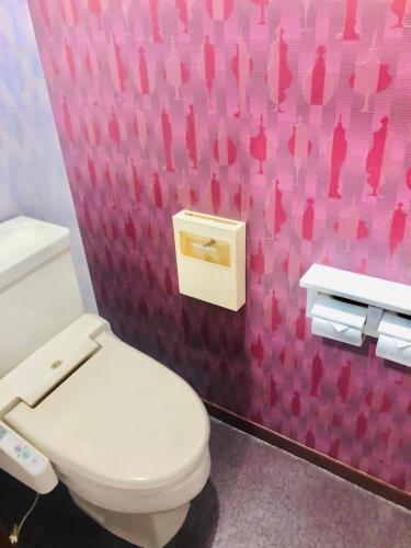 横浜市にあるfannys hotelのピンクの壁のバスルーム(白いトイレ付)