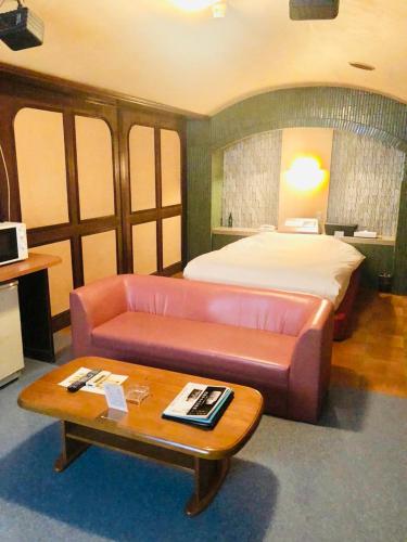 横浜市にあるfannys hotelのベッド、ソファ、テーブルが備わる客室です。