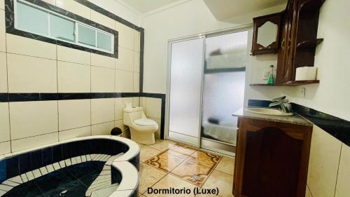 een badkamer met een bad, een toilet en een wastafel bij Samay Hostel in Juayúa