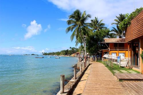 a boardwalk next to a house and the water at Suíte, Bem localizado em Morro de São Paulo Ba in Cairu