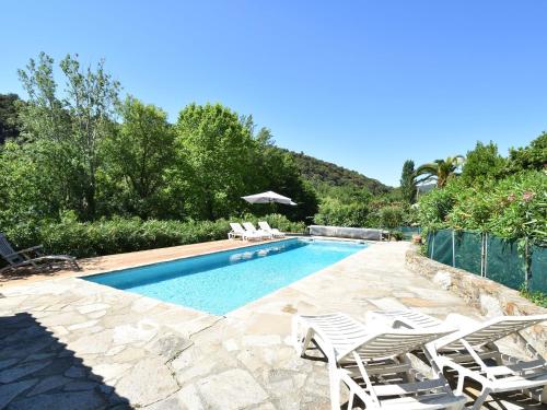 een zwembad met een groep stoelen en een zwembad bij villa with private swimming pool in Roquebrun