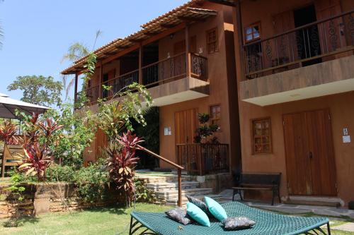 a patio in front of a building with pillows on a table at Confraria da Prata Flats in Pirenópolis